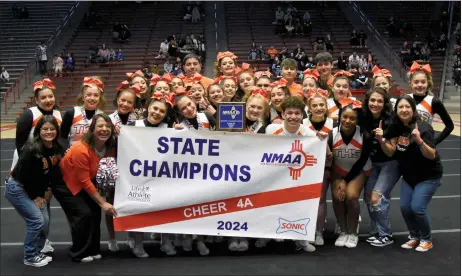  ?? ARCENIO J. TRUJILLO/Taos News ?? The Taos Tigers cheer team pose with their 2024 championsh­ip banner after the big announceme­nt was made on the floor of the UNM Pit April 6.