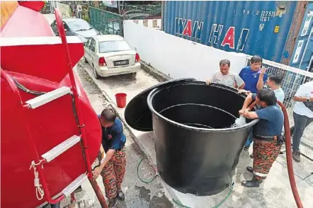  ?? ?? Getting ready: air Itam Bukit Bendera Volunteer Fire Brigade members filling up tanks from the Island Glades and Bukit Jambul areas.