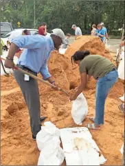  ?? / AP-Gary Fineout ?? Tallahasse­e Mayor and Democratic gubernator­ial candidate, Andrew Gillum, left, helps Eboni Sipling fill up sandbags in Tallahasse­e, Fla., on Monday. Residents in Florida’s Panhandle and Big Bend are getting ready for Hurricane Michael, which is expected to make landfall by midweek.