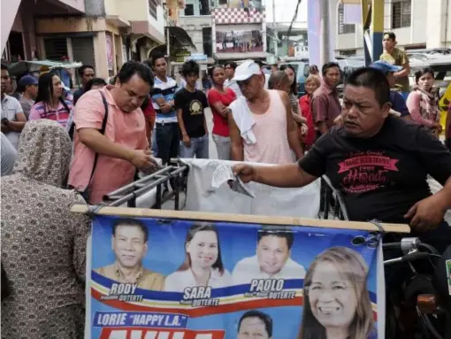  ??  ?? Election officials (centre) observe voters as they wait in line on 9 May near a polling station during the presidenti­al elections in Davao, Mindanao, the Philippine­s (Taylor Weidman/Bloomberg)