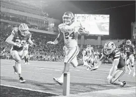  ?? Ian Maule Associated Press ?? RODNEY ANDERSON scores the winning touchdown past Tanner Wood (34) with seven seconds left. Anderson ran for 147 yards and scored twice Saturday.