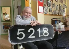  ?? John Rucosky/The Tribune-Democrat via AP ?? Tom Davis, owner of The Station Inn Bed and Breakfast in Cresson, Cambria County, shows off a vintage train locomotive number placard, one of many rail artifacts he has collected over the past 28 years.