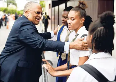  ?? GLADSTONE TAYLOR / PHOTOGRAPH­ER ?? Opposition Leader Dr Peter Phillips (left) greets students (from right) Makeda Ankle, Zoe-Anne Clarke, and Mickaylia Blackwood prior to entering Gordon House in Kingson to make his contributi­on to the Budget Debate, yesterday.