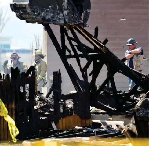  ?? Daily Times Call via AP) (Matthew Jonas/The ?? In this April 18, 2017, photo, investigat­ors stand by as debris is removed from a house that was destroyed in a deadly explosion in Firestone, Colo., on April 17. Anadarko Petroleum said Wednesday, April 26, that it operated a well about 200 feet (60...