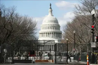  ?? Rebecca Blackwell/Associated Press ?? National Guard troops walk outside the U.S. Capitol in Washington on Jan. 22. The strong military presence and security perimeter establishe­d ahead of President Joe Biden’s inaugurati­on shrank in the days following.