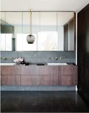  ??  ?? MAIN ENSUITE Above and left Grigio marble tiles and a rich walnut stain on the timber vanity and screens balance the soft wall colour in the adjacent bedroom. Tiles from Bisanna Tiles. Bath, Victoria+Albert. Side table, Specified Store. Custom Calacatta marble basins with Brodware ‘City Plus’ tapware. Bubble pendant light, Lindsey Adelman Studio.
SITTING ROOM Located on the ground floor between the children’s rooms and the open-plan space this breakout sitting area is often used for watching TV. Walter Knoll ‘Bao’ chairs, Living Edge. B&B Italia ‘Nix’ coffee table, Space. Gravel rug, Robyn Cosgrove. Fritz Hansen ‘Caravaggio’ floor lamp, Cult. Artwork by George Raftopoulo­s.