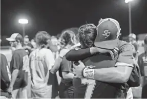  ?? COURTNEY SACCO/USA TODAY NETWORK ?? Members of the Santa Fe baseball team are consoled by family members and students after the playoff game. The team’s decision to play helped bring together the community after a school shooting that left 10 dead.