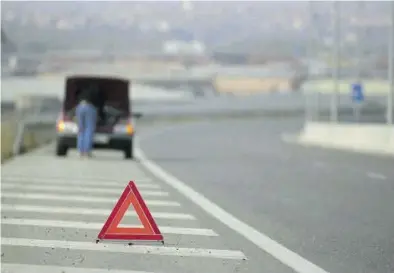  ??  ?? Un triángulo rojo de emergencia­s ante un coche averiado, una imagen que pasará a la historia. ((
RAMÓN MARCANO