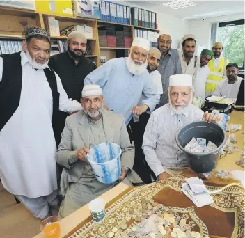  ??  ?? Members of the mosque committee counting the money raised