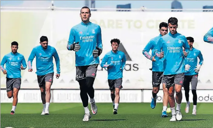  ??  ?? Los jugadores del Madrid hacen carrera continua en un momento del entrenamie­nto celebrado ayer en Valdebebas.