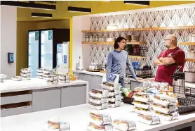  ?? Jessica Christian/The Chronicle ?? Glassdoor CEO Christian Sutherland-Wong, left, chats with an employee in the kitchen at Glassdoor’s office in San Francisco in 2022.