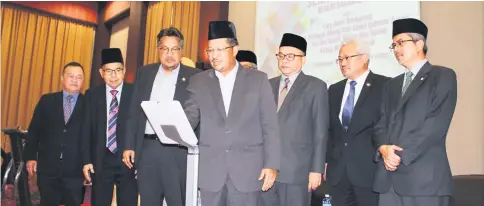  ??  ?? Misnu (fourth left) performs the gimmick to declare open the seminar on ‘wakaf’ at Miri Islamic Complex. Looking on are Ahmad Lai (second left), Abang Shibli (on Misnu’s right) and Kipli (on Misnu’s left).