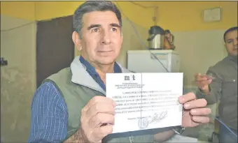  ??  ?? El comerciant­e Eligio Gómez Cristaldo exhibe la constancia de su absolución, expedido por el director de la cárcel regional de Concepción, el jueves último.