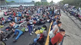  ?? EDGAR CLEMENTE/AP ?? Migrants block the highway during their caravan through Huixtla, Mexico, Nov. 8. Mexico has recorded nearly 590,000 undocument­ed migrants in its territory this year, according to government data.