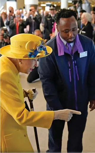  ?? ?? Tech lesson: Customer assistant Kofi Duah shows the Queen how to use an Oyster card on a ticket machine at Paddington station yesterday