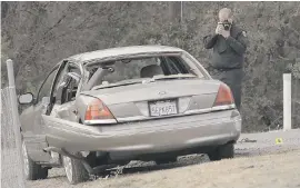  ?? THE ASSOCIATED PRESS ?? A California Highway patrol officer photograph­s a vehicle involved in a deadly shooting rampage at the Northern California rural community of Rancho Tehama Reserve on Tuesday. The gunman was shot dead by police.