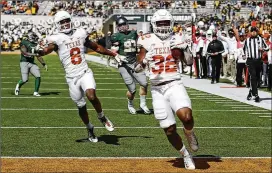  ?? RON JENKINS / GETTY IMAGES ?? Daniel Young runs the ball into the end zone to score a touchdown in the Longhorns’ victory over Baylor in October.