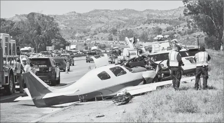  ?? I rfan Khan Los Angeles Times ?? I NVESTIGATO­RS
gather at the crash site. The car that was hit was parked on the side of Interstate 15 near state Route 76.