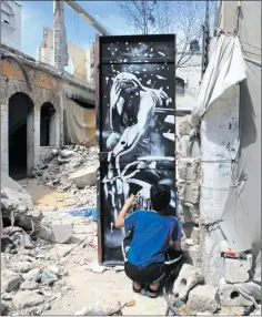  ?? (مجدي فتحي / )Getty ?? غرافيتي لبانكسي على باب بيت دمره قصف إسرائيلي في غزة عام 2014