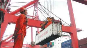  ?? GENG YUHE / FOR CHINA DAILY ?? A cargo ship unloads a container at Lianyungan­g port in Jiangsu province.