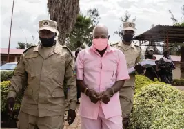  ?? SIMON WOHLFAHRT AFP via Getty Images/TNS ?? ‘Hotel Rwanda’ hero Paul Rusesabagi­na, in a pink inmate’s uniform, arrives at a court in Kigali, Rwanda, on Oct. 2, 2020.