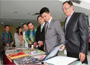  ??  ?? Checking it out: Chong looking at the works of the students during the launch of the contest in Petaling Jaya.