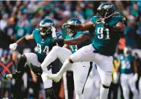  ?? CHRIS SZAGOLA/AP ?? The Eagles’ Josh Sweat, from left, Javon Hargrave and Fletcher Cox celebrate a tackle by Hargrave during Sunday’s game against the Tennessee Titans in Philadelph­ia.