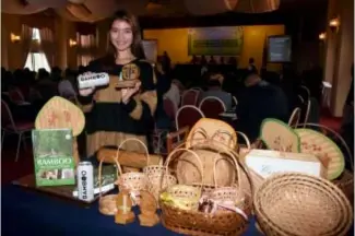  ?? RMC PIA-CAR ?? Baguio lass Carissa Collado shows products made from bamboo which includes a bamboo beer during the Bamboo Techno-Investment Forum and Roadshow in Baguio City last week.