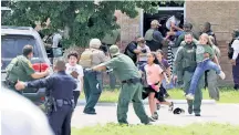  ?? ?? CHAOS: Robb Elementary students are helped to safety on Tuesday after escaping through the windows of the school, where a teen gunman’s rampage left 19 children and two teachers dead.