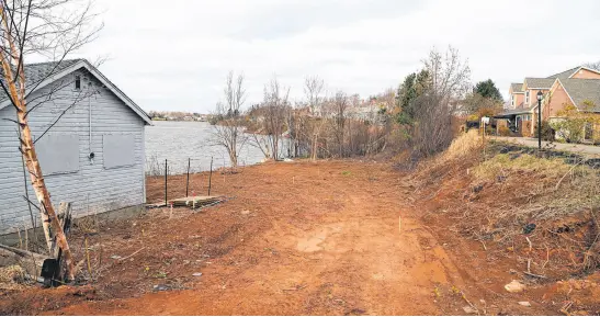  ?? CODY MCEACHERN • THE GUARDIAN ?? A property behind 1 Colonel Gray Dr. in Charlottet­own is looking a lot more bare after its new owners cleared the lot of trees, bushes and grass, destroying the property’s buffer zone, said Sjors Reijers, who lives next to the lot. He said the surroundin­g residents are frustrated the new owners have not received any penalty for removing the buffer zone and are concerned it may present future erosion issues.