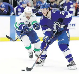  ??  ?? Lightning centre Brayden Point takes the puck to the net with Canucks defenceman Oscar Fantenberg in pursuit during the second period in Tampa.