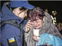  ?? UKRAINIAN EMERGENCY SERVICE VIA AP ?? An emergency service psychologi­st comforts a woman after a Russian drone attack on a residentia­l building in Odesa, Ukraine, on Tuesday. Nine people, including two infants and two other children, were injured in the strike.