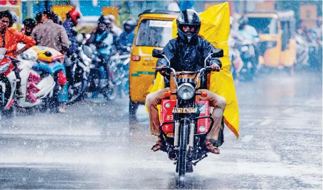  ?? Agence France-presse ?? ↑
A motorist rides on a road during heavy rain in Chennai on Monday.