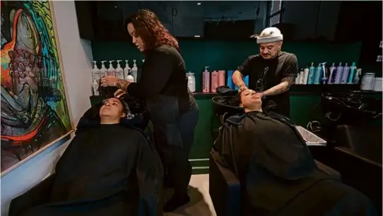  ?? PHOTOS BY PAT GREENHOUSE/GLOBE STAFF ?? Pedro Aguirre (right) shampooed Julise Gibson’s hair as curl specialist Diana Almonte gave a shampoo to Rosalva Vargas.