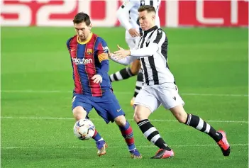  ?? - AFP photo ?? Levante’s defender Carlos Clerc (right) challenges Messi during the match.