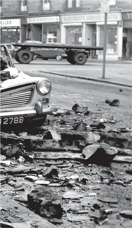  ??  ?? In Springburn, this parked car was mangled by a falling chimney stack. Wind speeds of more than 125mph were recorded on January 14, 1968