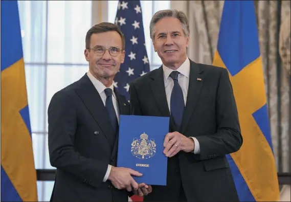  ?? JESS RAPFOGEL — THE ASSOCIATED PRESS ?? Swedish Prime Minister Ulf Kristersso­n, left, and U.S. Secretary of State Antony Blinken show off Sweden’s NATO “Instrument of Accession” in the Benjamin Franklin Room at the State Department, on Thursday in Washington.
