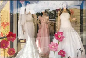  ?? (File Photo/AP/
Suman Naishadham) ?? Mannequins in wedding gowns are seen March 15, 2021, in a window display at a bridal store in Nogales, Ariz., that had been closed for nearly a year because of the pandemic.
