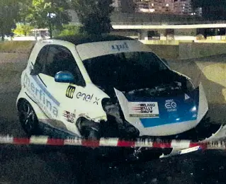  ??  ?? L’auto che ha investito il commissari­o dopo essere uscita dal tracciato ad alta velocità nelle vicinanze del Vigorelli. Un commissari­o di corsa è grave in ospedale. A fianco la passerella in centro di uno dei bolidi