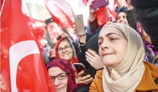  ??  ?? Supporters wave Turkish national flags during the inaugurati­on ceremony of Turkey's first automated urban metro line on the Asian side of Istanbul. (AFP)