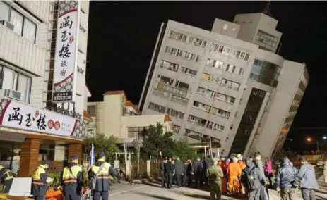  ?? PAUL YANG/AFP/GETTY IMAGES ?? Rescue workers block off an area to search for survivors outside a tower listing after a 6.4-magnitude earthquake in Hualien, Taiwan, on Wednesday.