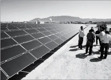  ?? ASSOCIATED PRESS ?? IN THIS APRIL 2011 FILE PHOTO, OFFICIALS with Arizona-based First Solar and Public Service Company of New Mexico gather after the dedication of the utility’s new 2-megawatt photovolta­ic solar array in Albuquerqu­e, N.M.