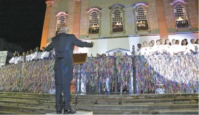  ??  ?? Os pequenos cantores foram distribuíd­os entre o gradil da igreja e as cinco janelas da Basílica do Bonfim