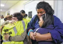  ?? AP PHOTO ?? Rescue team members merge into a hug as they wait to go out to attend several calls for help from citizens in need of assistance during the impact of Maria, a category 5 hurricane that hit Puerto Rico Tuesday.