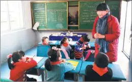  ?? PHOTOS BY WANG JIAN / CHINA DAILY ?? Zhi Yueying gives a Chinese lesson to students at the primary school in Baiyang, Fengxin county, in Jiangxi province.