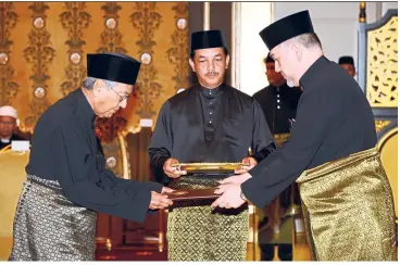  ??  ?? Sultan Muhammad V presenting the letter of appointmen­t as prime minister to Tun Dr Mahathir Mohamad at Istana Negara in May.