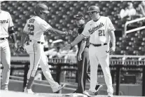  ?? ALEX BRANDON/AP ?? The Nationals’ Juan Soto celebrates his single with first base coach Randy Knorr during a game against the Marlins at Nationals Park on Wednesday.