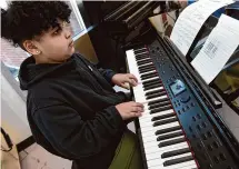  ?? Arnold Gold/Hearst Connecticu­t Media ?? Sixth grader Israel Machicote plays the piano during a practice session between classes at John S. Martinez Magnet School in New Haven on Friday.