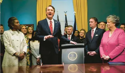  ?? STEVE HELBER/AP ?? Gov. Glenn Youngkin, second from left, addresses the media as he prepares to sign executive orders in the governor’s conference room in Richmond in 2022. Among these was Executive Order No. 9, which aims to withdraw Virginia from the Regional Greenhouse Gas Initiative.