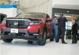  ?? DAVID ZALUBOWSKI/AP ?? Customers confer with a salesperso­n April 15 at a Honda dealership in Highlands Ranch, Colo.